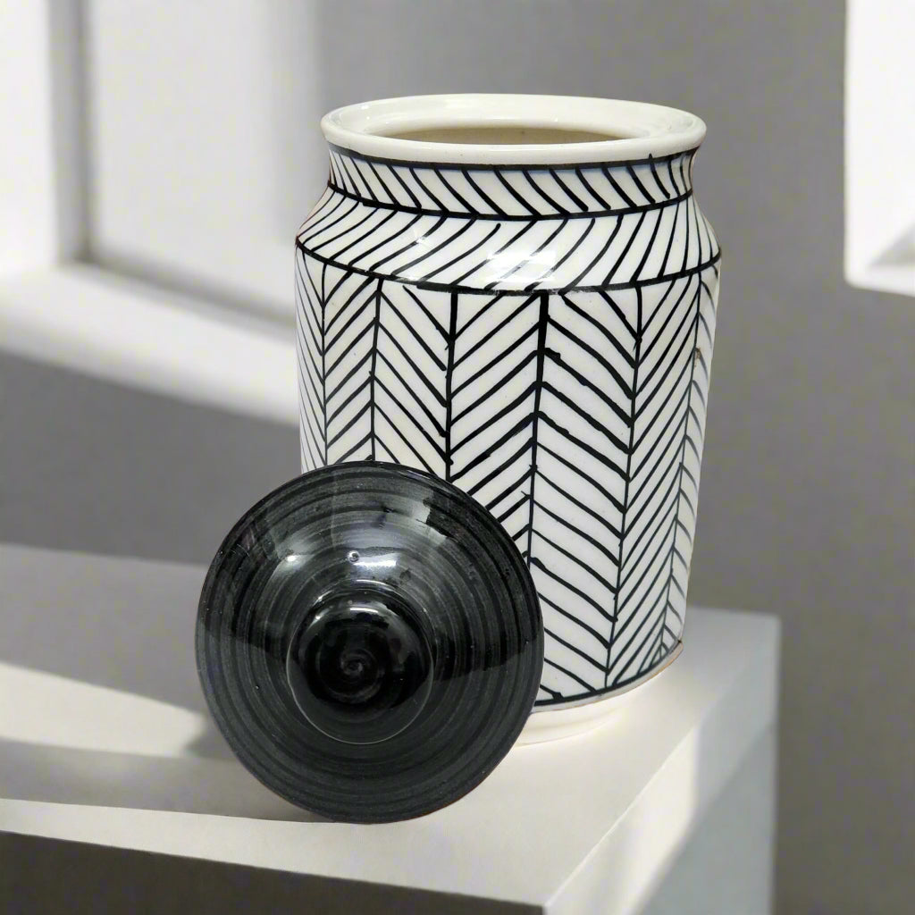 Black and white ceramic jar with geometric herringbone pattern and black lid, ideal for kitchen storage or home décor