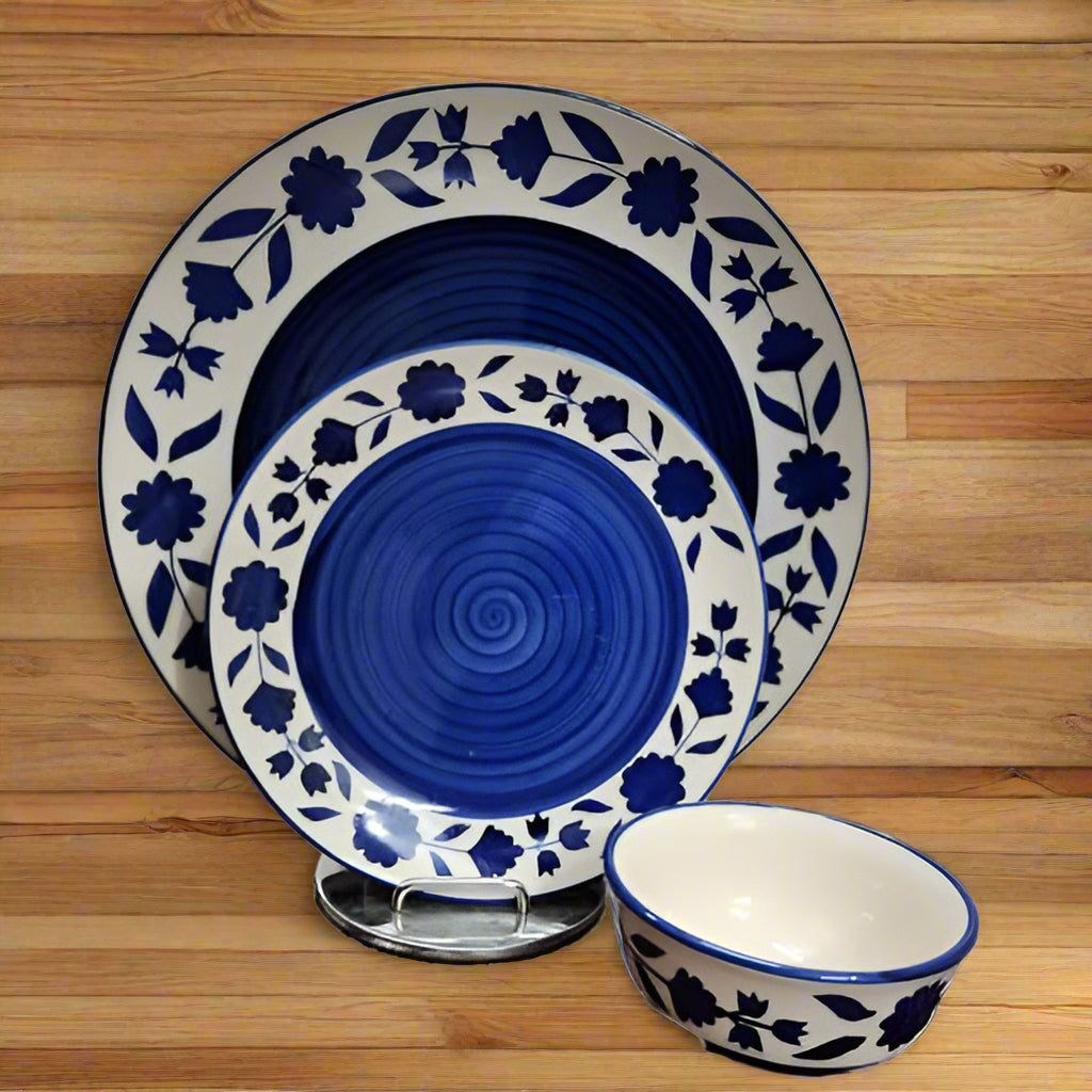 Handcrafted ceramic dinnerware set including plates, bowls, and platters displayed on a dining table