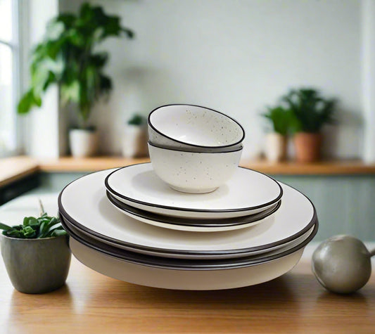 6-piece white ceramic dinnerware set with black border, including plates and bowls, displayed on a dining table with a modern minimalist background